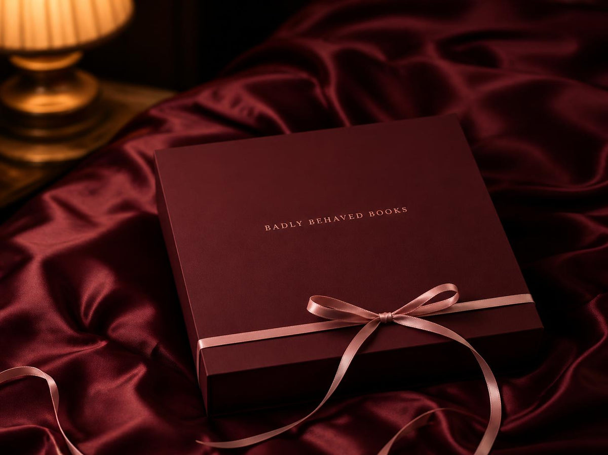 Inside the spicy book subscription box: a book, candle and cherries on silk sheets